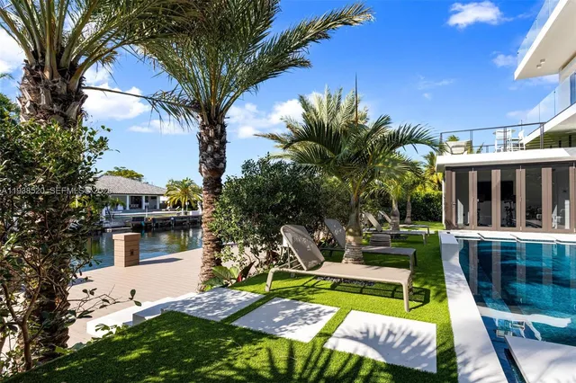 a living room with patio furniture and a potted plant