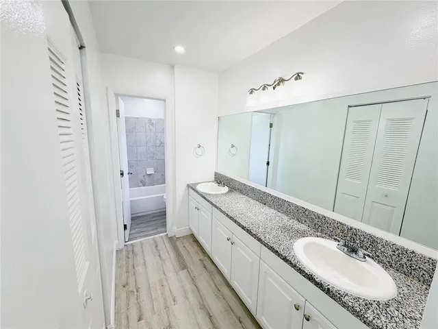 a spacious bathroom with a granite countertop sink mirror and a shower