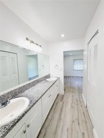 a spacious bathroom with a granite countertop sink and a mirror