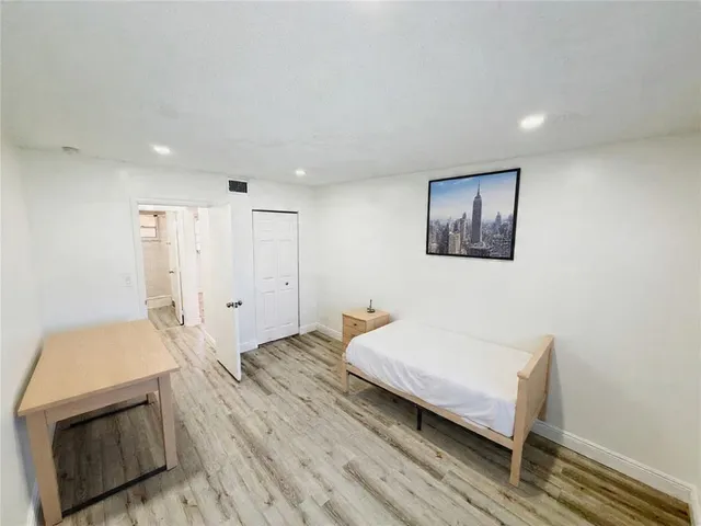 a bedroom with a bed and a view of kitchen