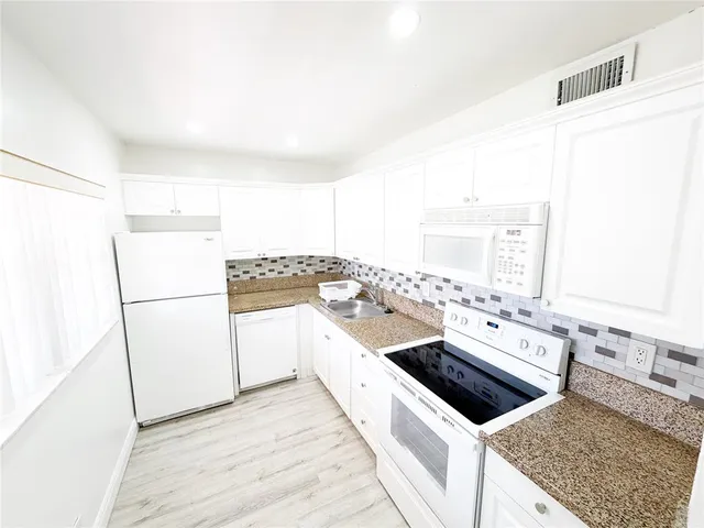 a kitchen with a stove a sink and a refrigerator