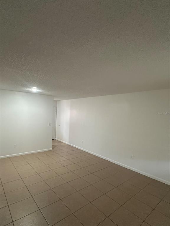 2218 Leo Drive, Unit B Auburndale, FL 33823 - Photo 2 of 9 an empty room with white walls and tiles