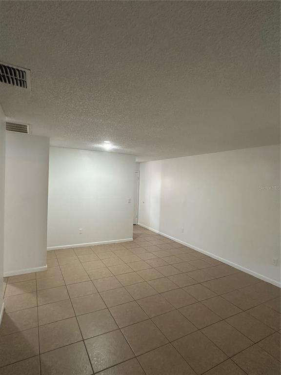 2218 Leo Drive, Unit B Auburndale, FL 33823 - Photo 3 of 9 an empty room with white walls and tiles
