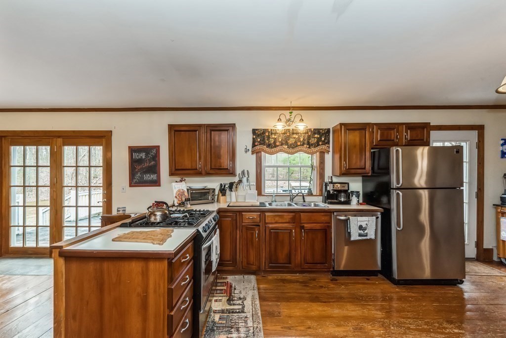 50 Old Poor Farm Road Ware, MA 01082 - Photo 13 of 33 a kitchen with stainless steel appliances granite countertop a refrigerator a sink a stove and island