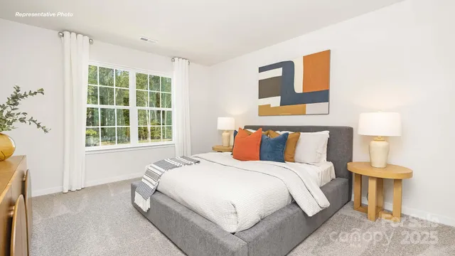 a large bed sitting in a bedroom next to a window