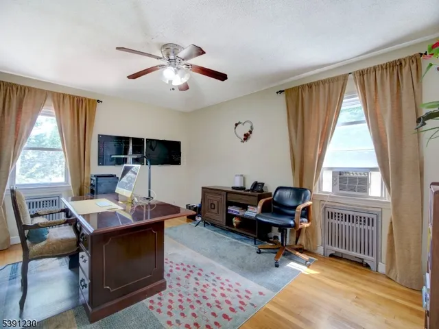 a view of a workspace with furniture and a window