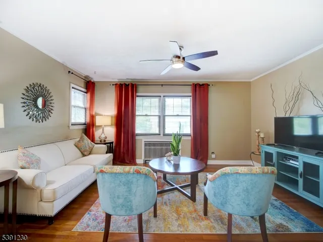 a living room with furniture a flat screen tv and a large window