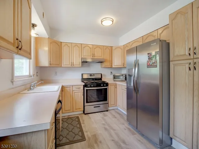 a kitchen with granite countertop a refrigerator stove and sink
