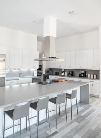 a kitchen with cabinets a sink and chairs in it