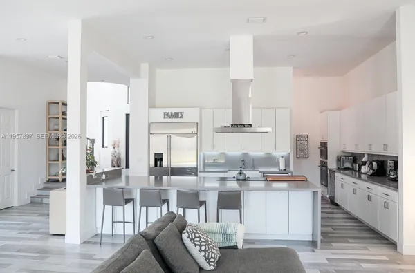a kitchen with stainless steel appliances kitchen island granite countertop a table and chairs