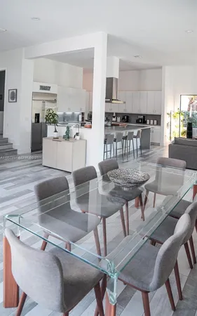a kitchen with stainless steel appliances kitchen island granite countertop a table and chairs