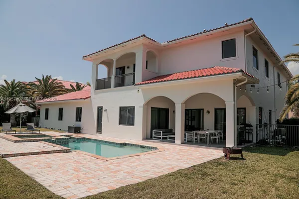 a view of a white house with palm trees