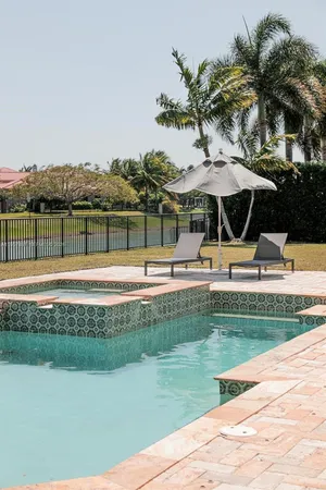 a view of a white house with a swimming pool and sitting area