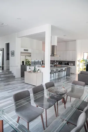 a living room with stainless steel appliances furniture and a kitchen view