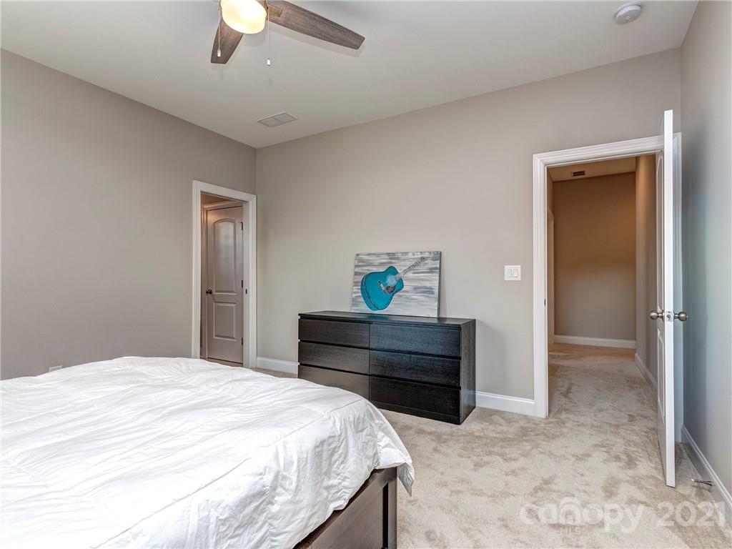 10007 Sunset Ridge Midland, NC 28107 - Photo 22 of 34 a bedroom with a bed and a chandelier