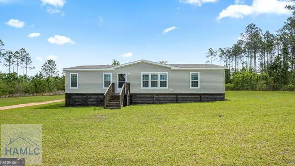 a view of a house with patio and a yard