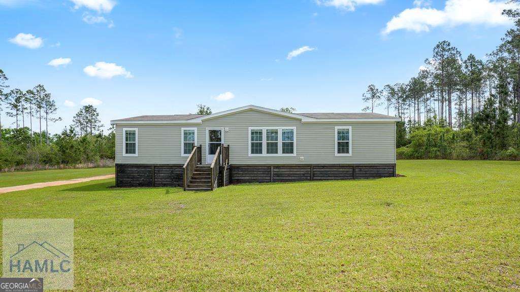 a view of a house with patio and a yard