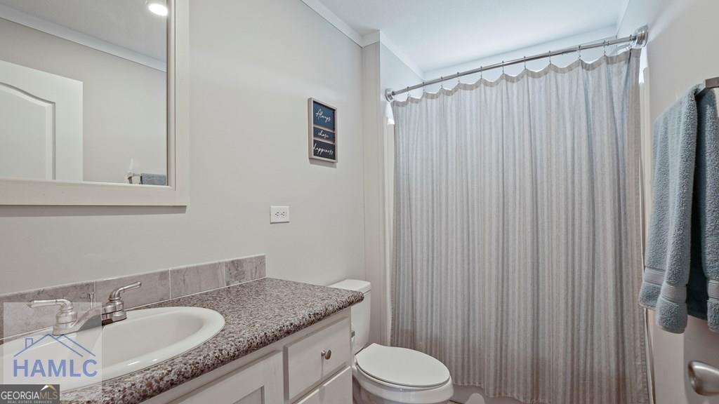 876 Hires Road Jesup, GA 31545 - Photo 23 of 30 a bathroom with a granite countertop sink toilet and shower