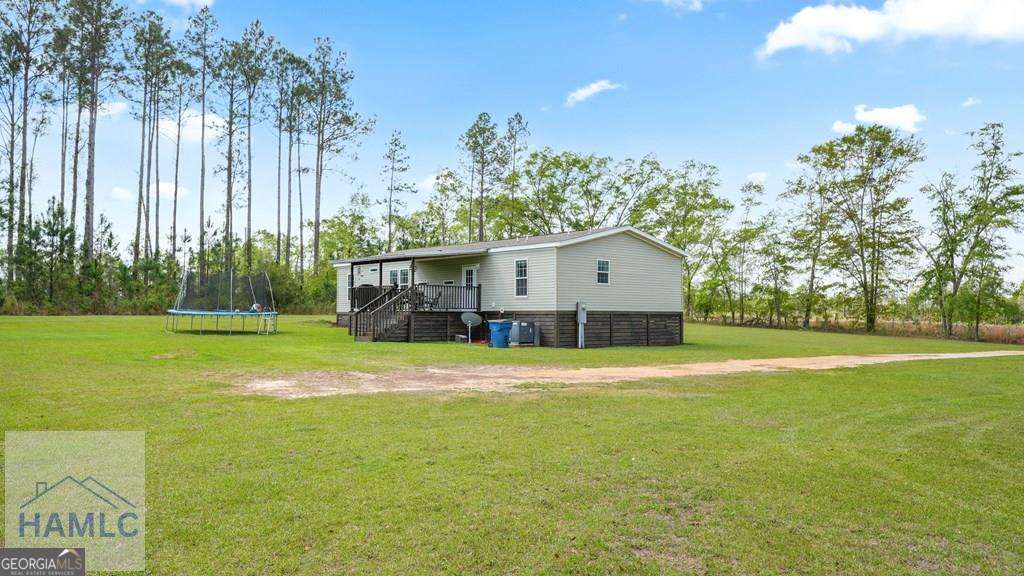 876 Hires Road Jesup, GA 31545 - Photo 24 of 30 a front view of house with yard and trees