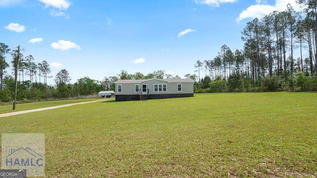 876 Hires Road Jesup, GA 31545 - Photo 28 of 30 a view of a green field with trees in the background