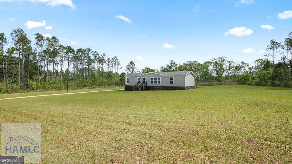 876 Hires Road Jesup, GA 31545 - Photo 29 of 30 a view of a big room with trees in front of it