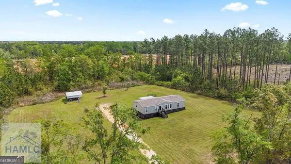 a aerial view of a house with swimming pool next to a yard