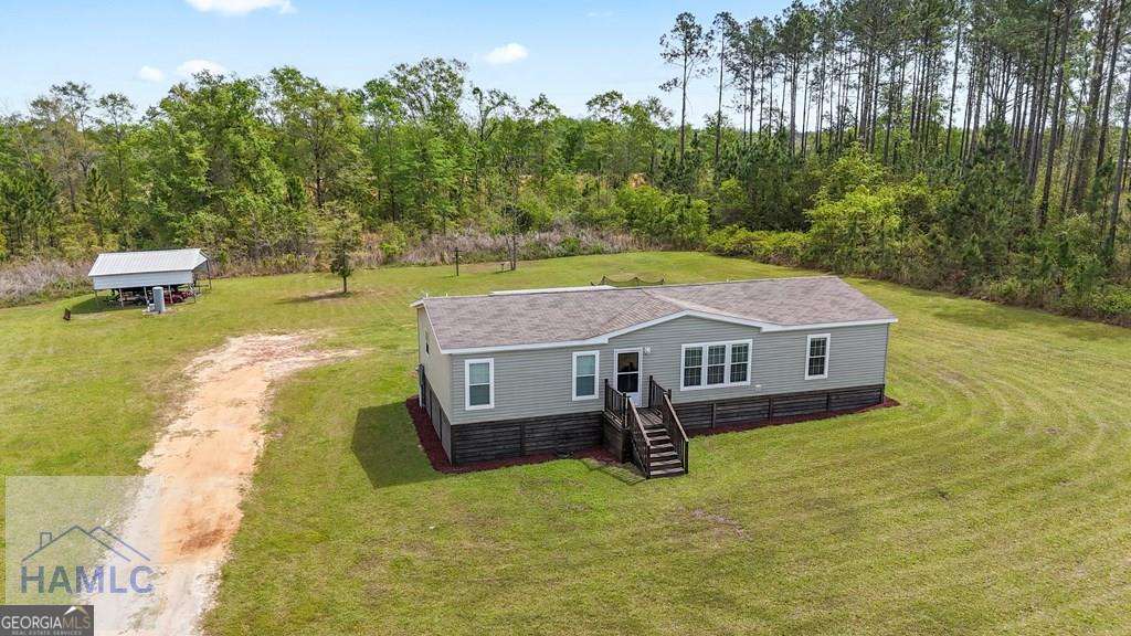 876 Hires Road Jesup, GA 31545 - Photo 6 of 30 a aerial view of a house with swimming pool next to a yard