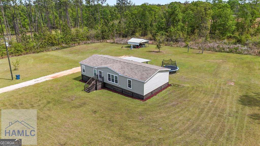 876 Hires Road Jesup, GA 31545 - Photo 7 of 30 a swimming pool with some trees in the background
