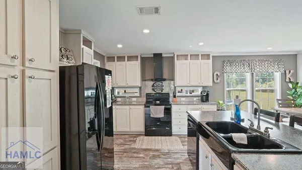 a kitchen with a refrigerator and a stove top oven