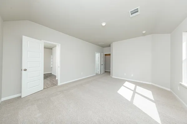 an empty room with windows and entrance to other room