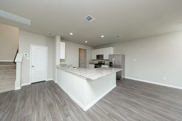 a large kitchen with stainless steel appliances a large counter top and a stove