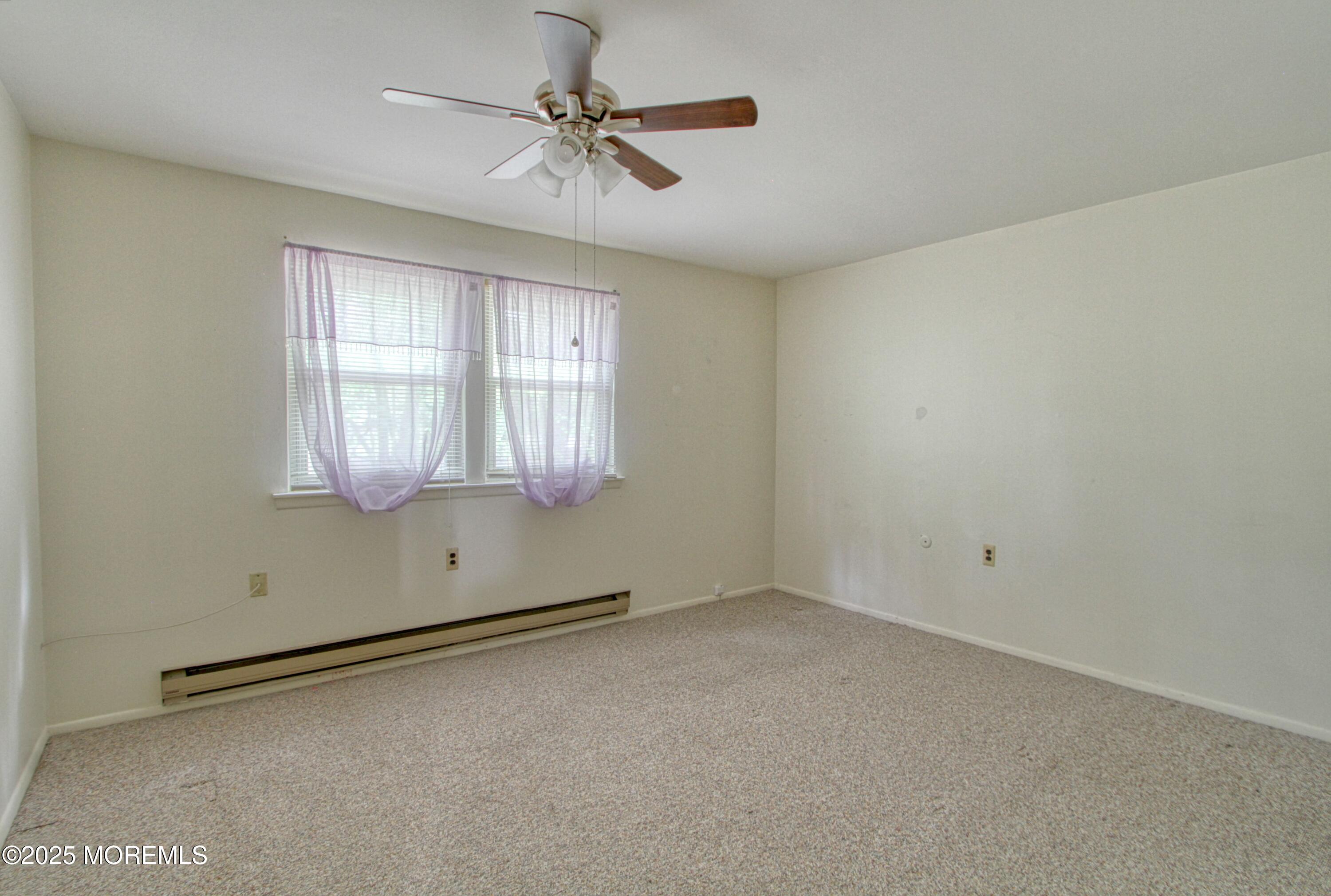 18 Moccasin Drive, Unit D Whiting, NJ 08759 - Photo 5 of 15 an empty room with chandelier fan and windows