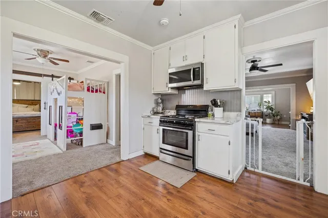 a kitchen with stainless steel appliances granite countertop a stove and white cabinets