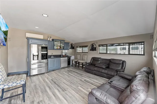 a living room with furniture a computer on the desk and chair with wooden floor