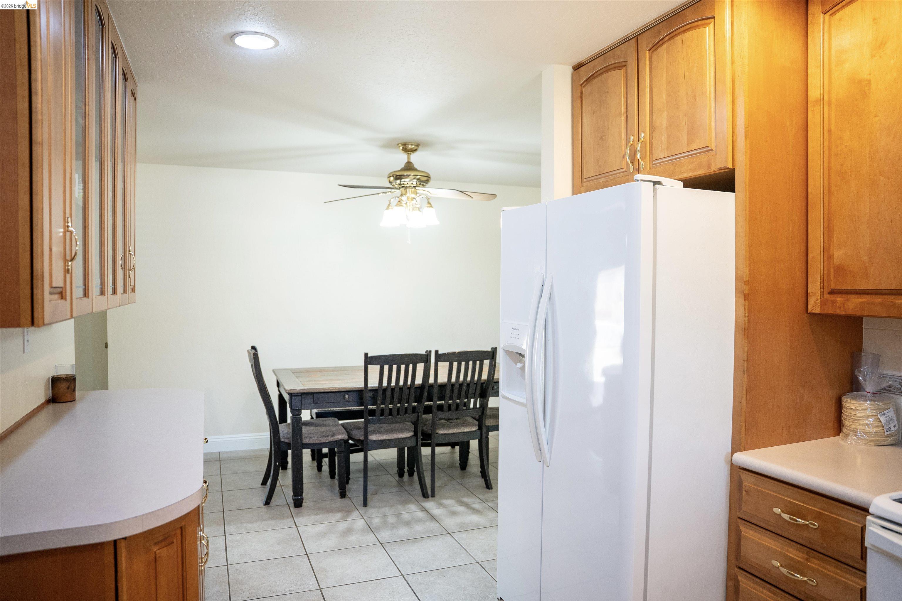 3513 Rio Grande Drive Antioch, CA 94509 - Photo 8 of 22 Kitchen featuring wood-finish cabinetry, light-colored countertops, white appliances, and a tiled floor
