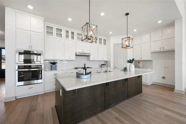 a living room with furniture kitchen view and a wooden floor