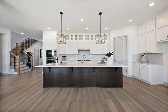a kitchen with granite countertop a sink stove and wooden floor