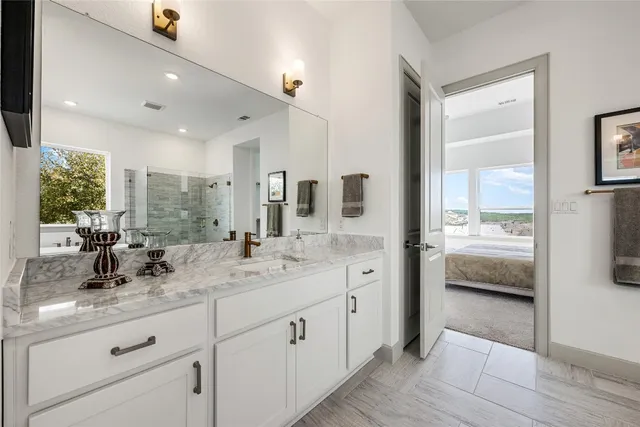a spacious bathroom with a granite countertop sink and a mirror
