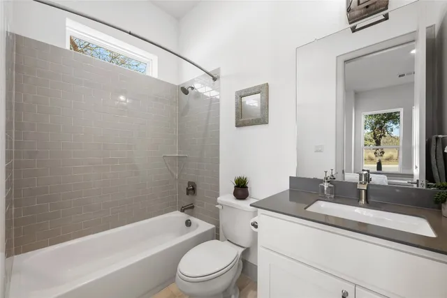 a spacious bathroom with a double vanity sink a mirror a bathtub and window
