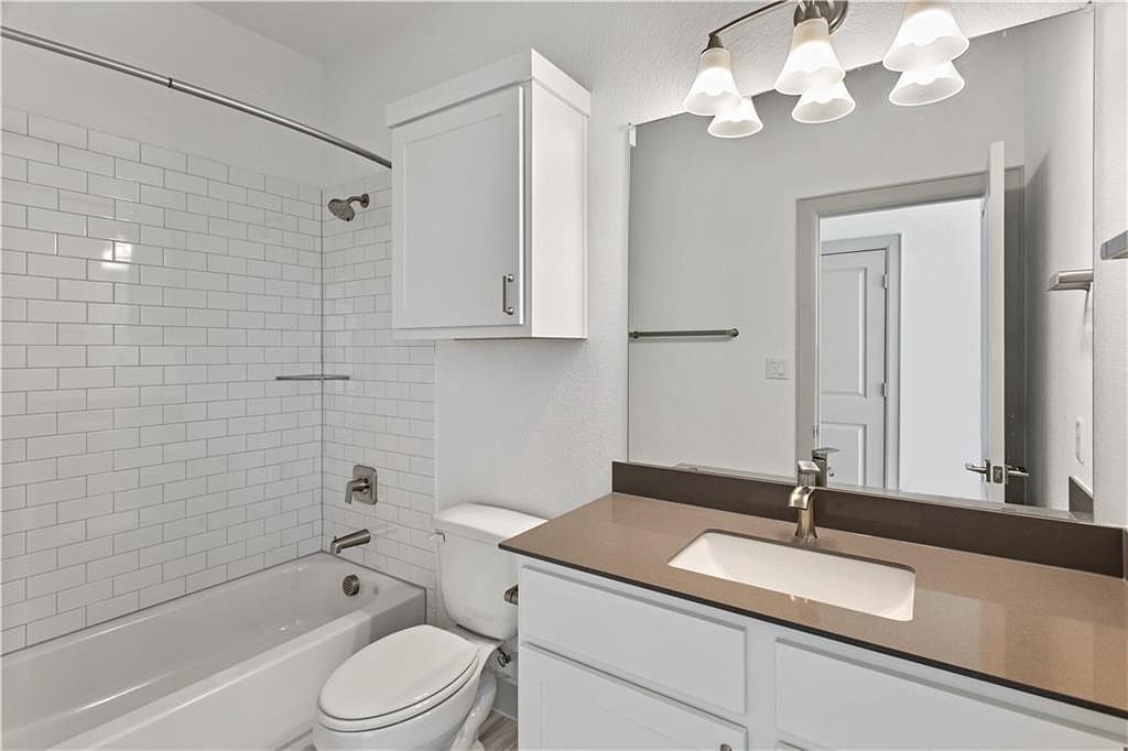 298 Smoke Tree Circle Dripping Springs, TX 78620 - Photo 27 of 38 a bathroom with a granite countertop sink a toilet and shower