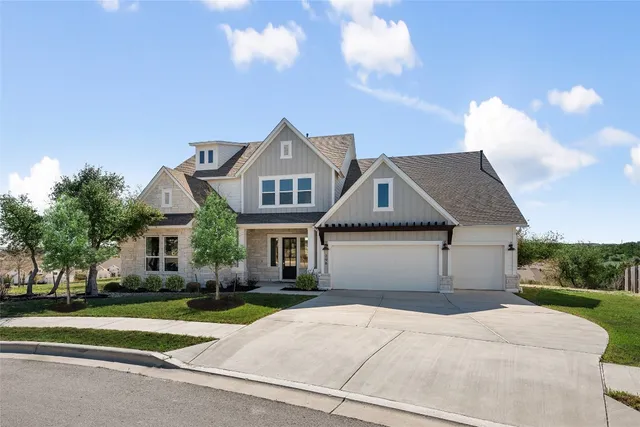 a front view of a house with a garden and trees