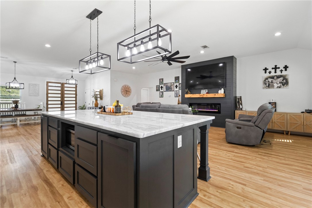 906 3rd Street Valley Mills, TX 76689 - Photo 19 of 52 a kitchen with stainless steel appliances granite countertop a kitchen island a stove and a wooden floors