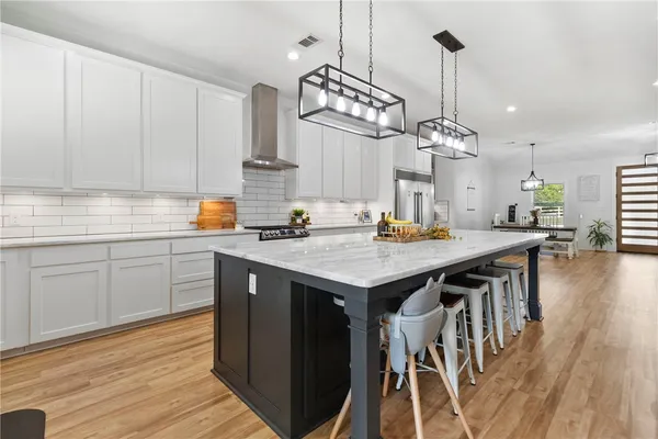 a kitchen with wooden floor and chairs