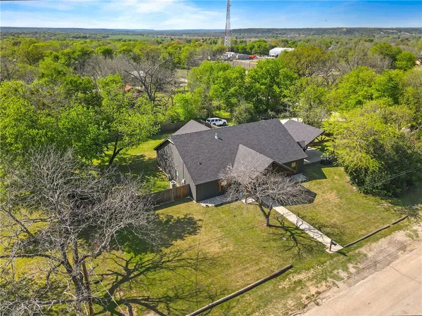 a aerial view of a house with swimming pool and large trees