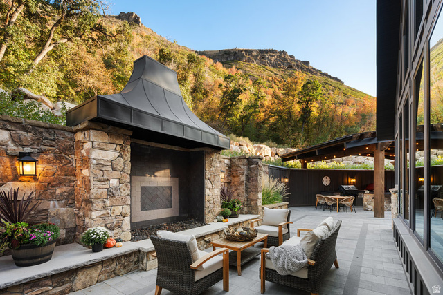 1141 South Oak Leaf Lane Springville, UT 84663 - Photo 124 of 147 Expansive hardscaped patio featuring a stone fireplace with a metal hood, a covered outdoor kitchen area, and large format windows