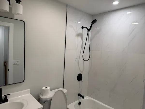 a bathroom with a sink a toilet and shower