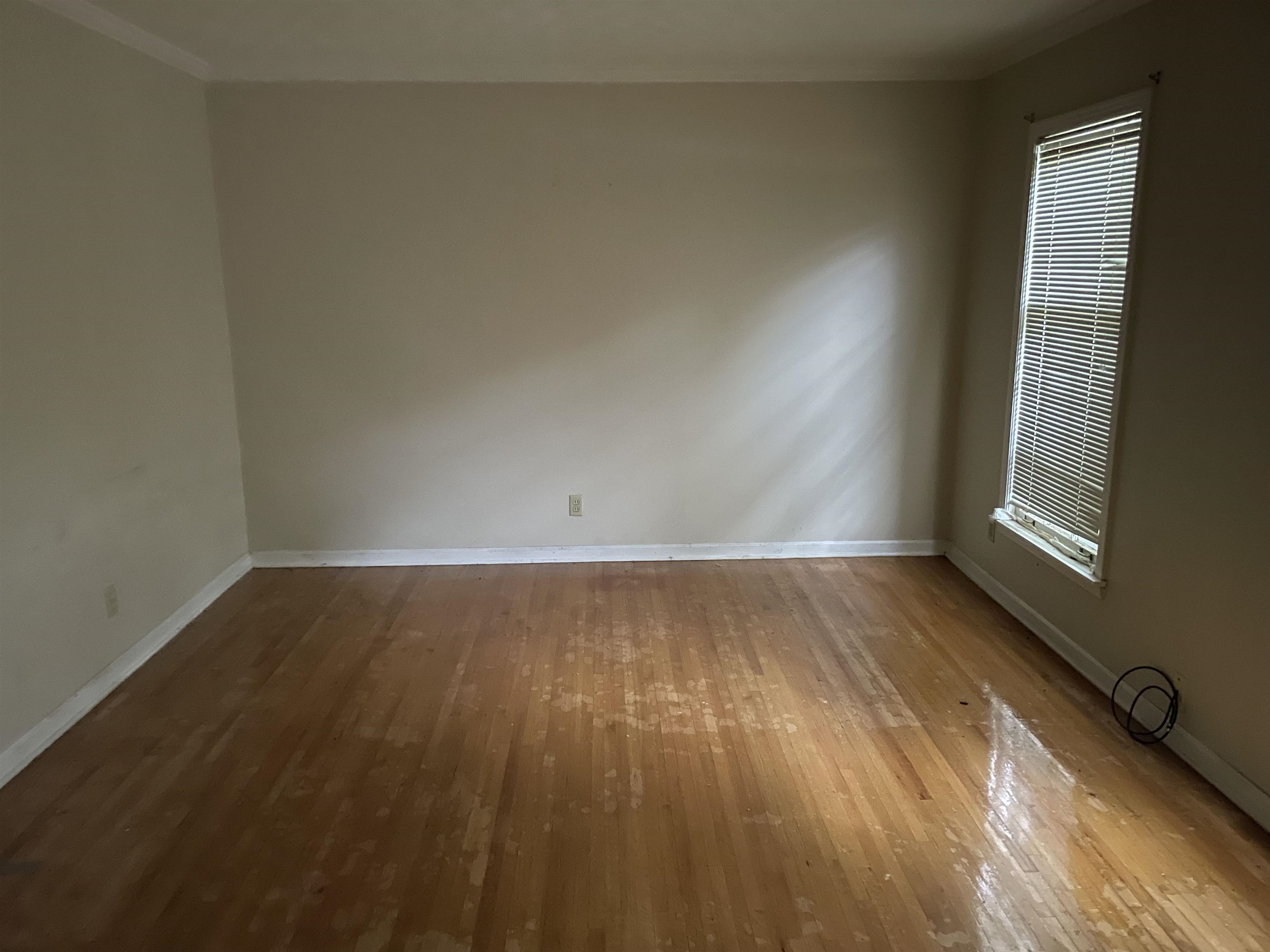4505 Yale Road Memphis, TN 38128 - Photo 3 of 5 an empty room with wooden floor and windows
