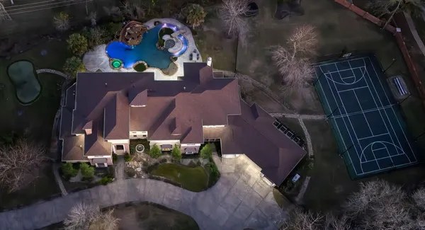 an aerial view of a house with a yard and lake view