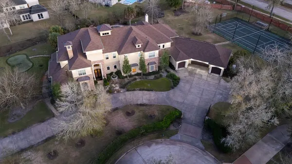 an aerial view of a house with a yard and lake view