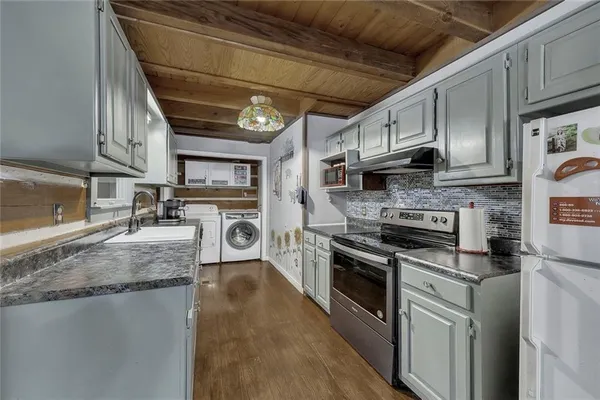 a kitchen with stainless steel appliances granite countertop a stove sink and cabinets